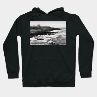 Rough waves hit the rocks near Dunstanburgh castle in Northumberland, UK Hoodie